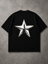 A black short-sleeve t-shirt with a large white star graphic printed on the back, laid flat on a textured gray background.