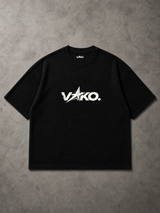 A black short-sleeve ribbed t-shirt with a white 'VAKO.' logo printed across the chest, laid flat on a textured gray background.